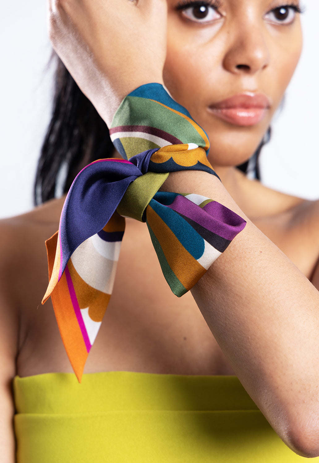 Woman styling a colourful Pashmisy Italian silk scarf