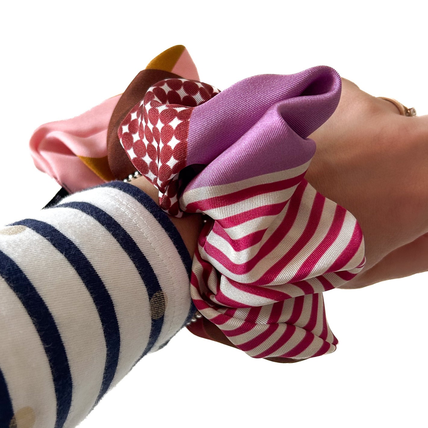 Vibrant pink striped Italian silk scrunchie worn on the wrist as a colourful accessory. Ethical hair accessories and a gift for fashion lovers